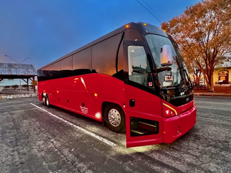 Red and black MCI charter bus parked on a street